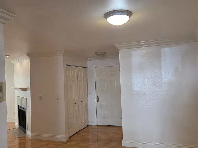 View of the entrance to the unit. Behind the double doors is a spacious storage, where the washer-dryer is located.