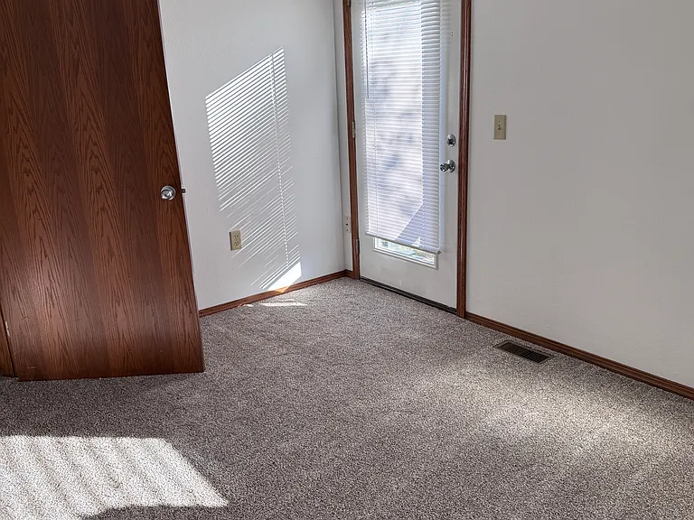 Larger bedroom with vaulted ceiling and back patio door. And large closet.