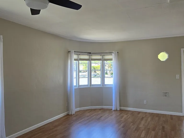 Curved Wall of Multiple Window Panels & Gleaming Hardwood Floors