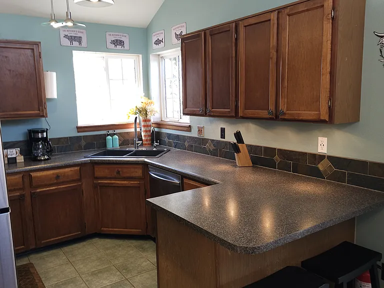 Kitchen with toaster, electric stove, silverware, cooking utensils, and pots ^ pans
