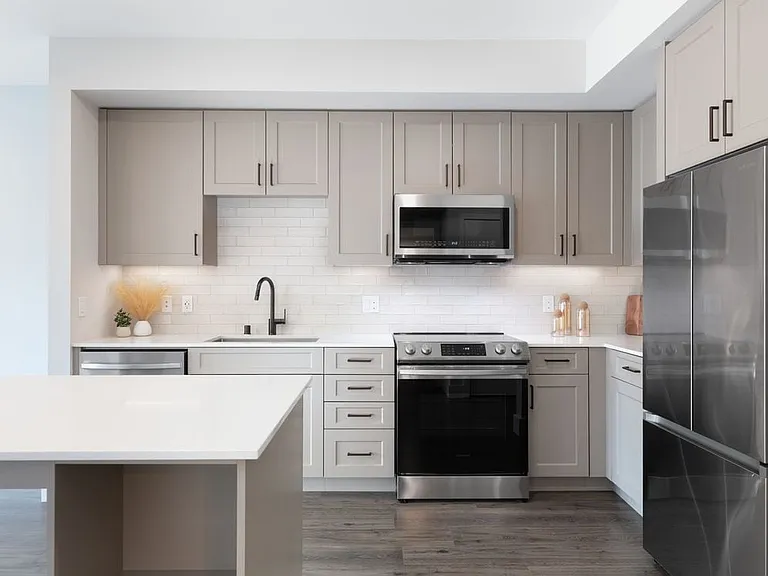 Finish Package II Kitchen with beige cabinetry, white tile backsplash, white quartz countertops, and hard surface flooring