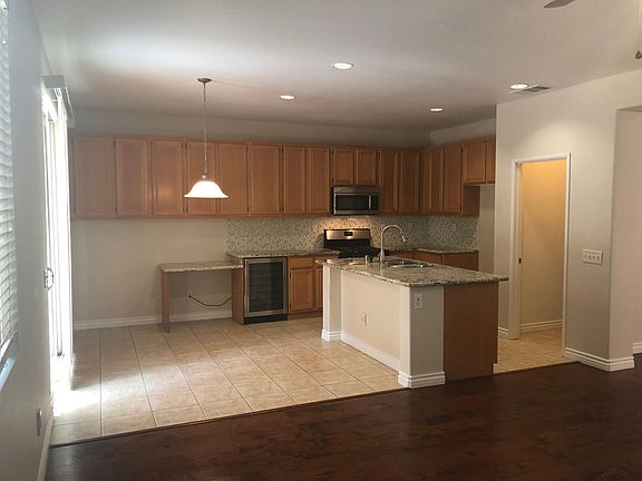 Upgraded kitchen with tile floors, granite counter, beverage fridge and walk-in pantry.