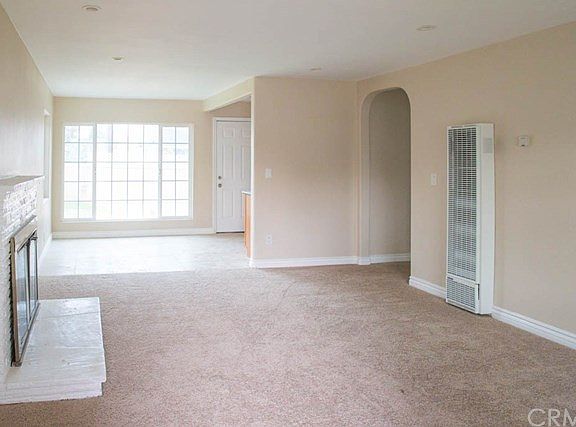 The Living Room with Fireplace and Wall Heater.