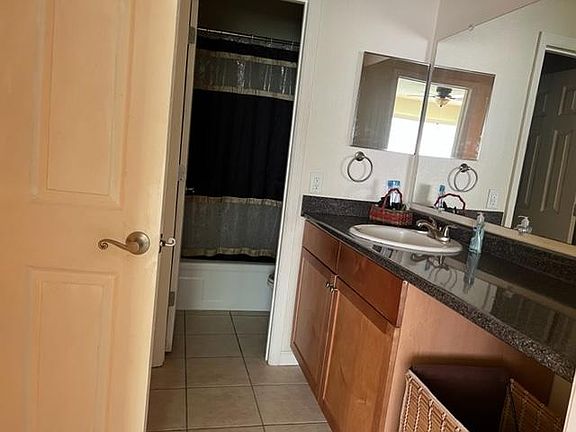 Bathroom with tub, large vanity with cabinets and linen closet.