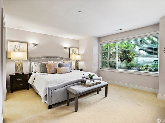 Primary bedroom with an expansive window looking out to the lush garden area
