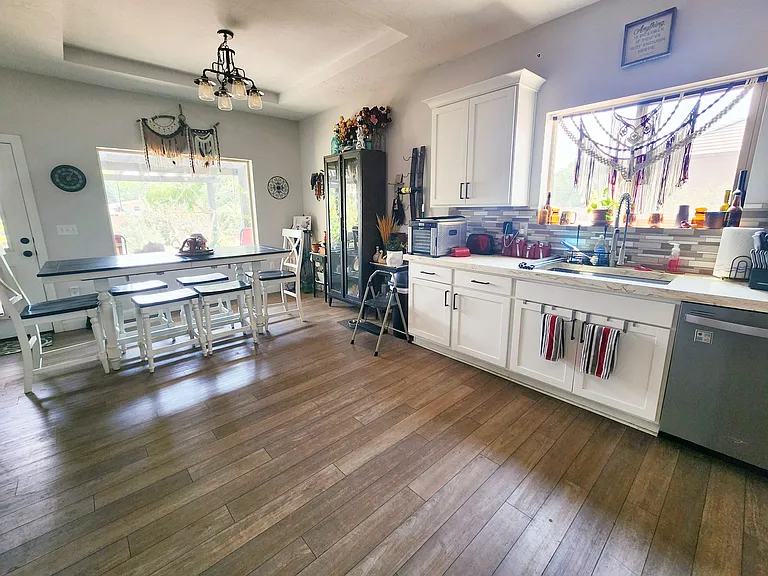 Kitchen with large windows, finished concrete countertops and custom white cabinetry