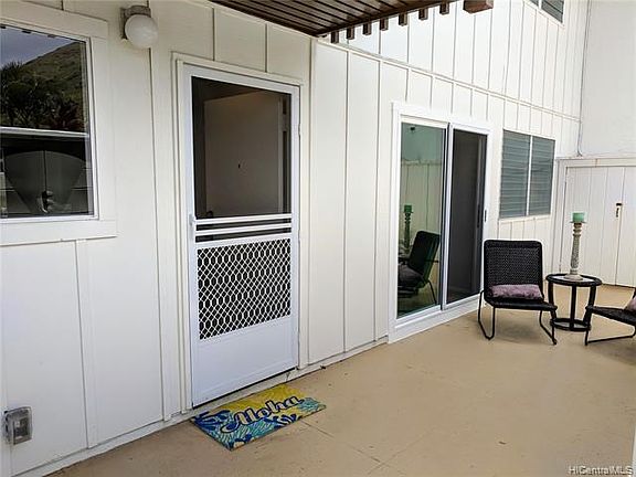 Looking from keyed front gate to front door and lanai area.  Screen door allows breezes to flow through living area.