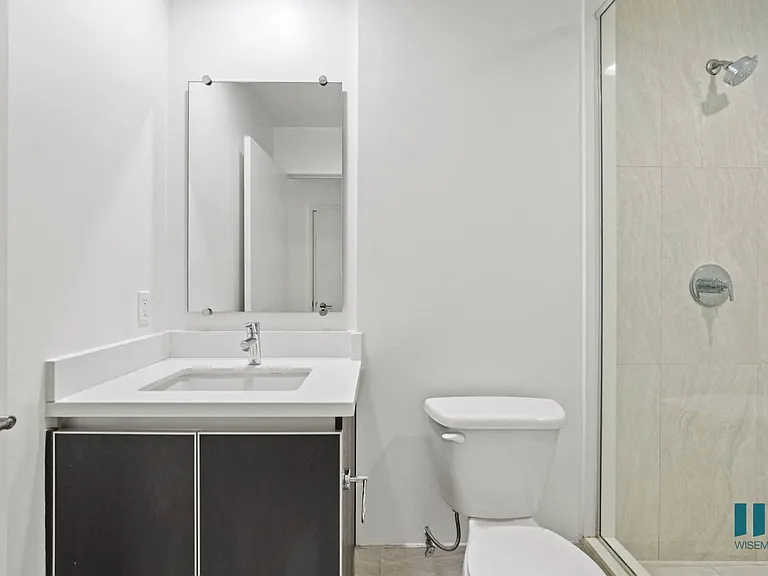 Bathroom with Walk-In Shower with Glass Door and Vanity Cabinet Storage