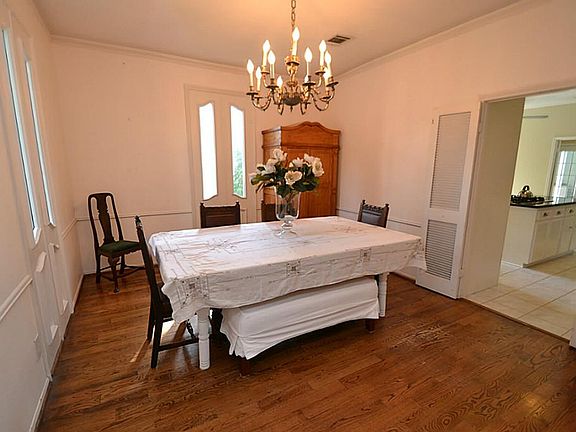 Dining room dazzled by hardwood floors, crown molding and ac