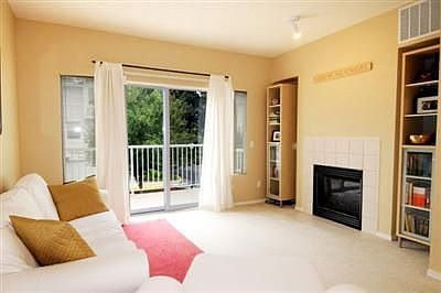 Living room with gas fireplc leads to balcony