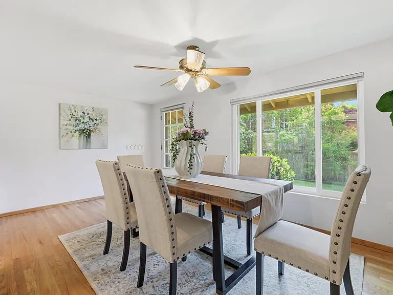 Sunlit dining space framed by large windows
