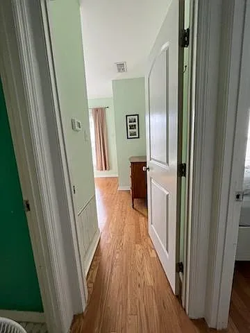 Hallway between full bath and first bedroom, leading into second bedroom.