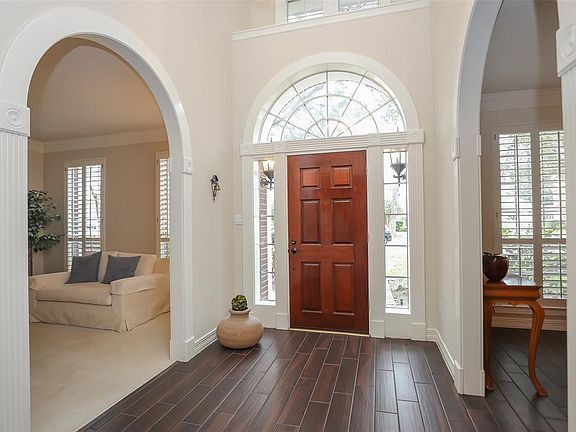 Solid wood front door with arched window above and side windows for maximum light. Arched entrances to the living and dining rooms compliment the door.
