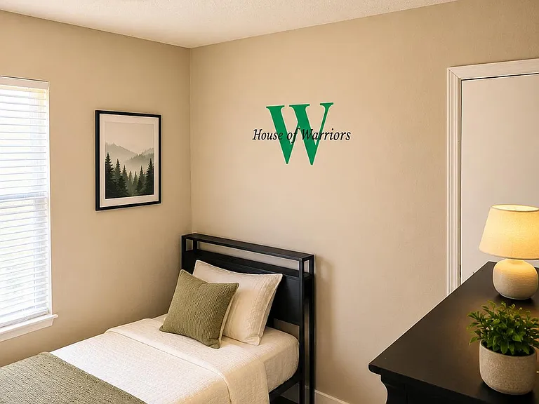 Furnished bedroom with a twin bed, dresser, and a window with blinds plus overhead fan/light for comfortable daily use.