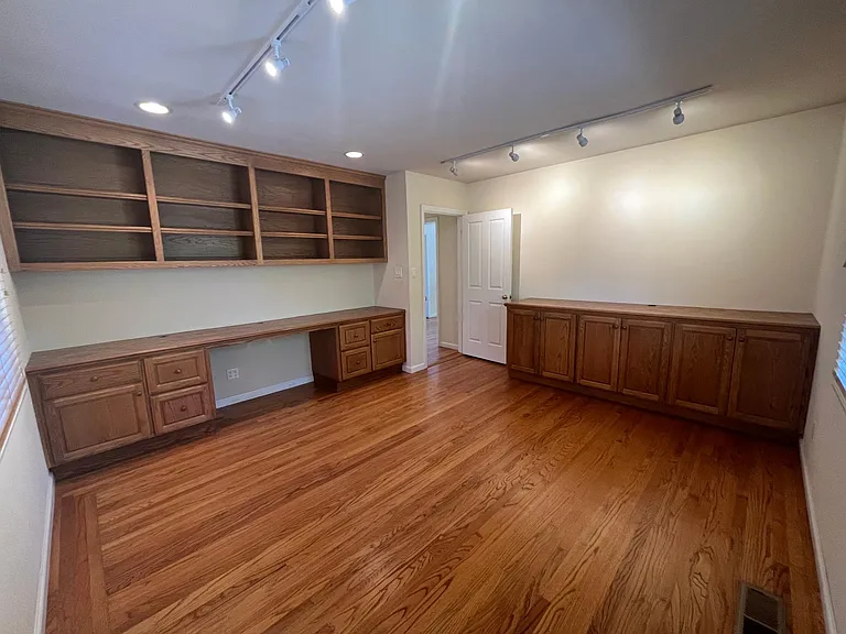 Private office is beautifully appointed with built-in wall desk, shelves and cabinetry. This versatile space may also serves as a fourth bedroom.