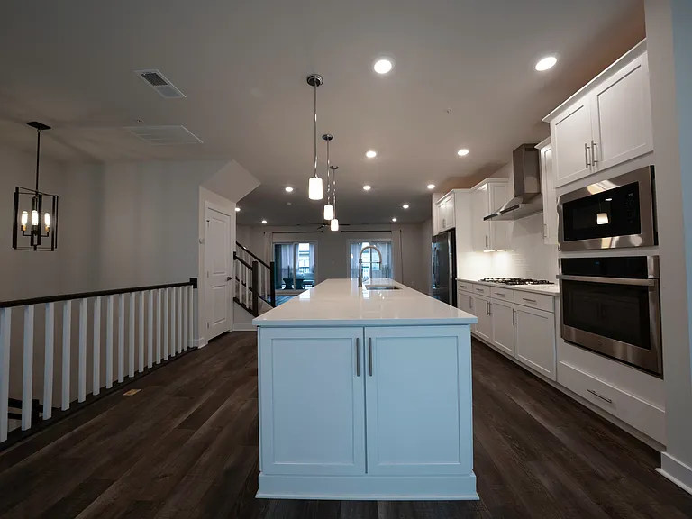 Kitchen features stainless steel appliances, gas range, large island, quartz countertops, under-cabinet lighting and outlets, lots of cabinetry and overhead lighting. Lights are smart/WiFi-enabled.