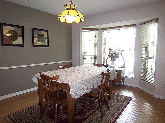 Lovely formal dining room boasts wood laminate flooring and bay window.