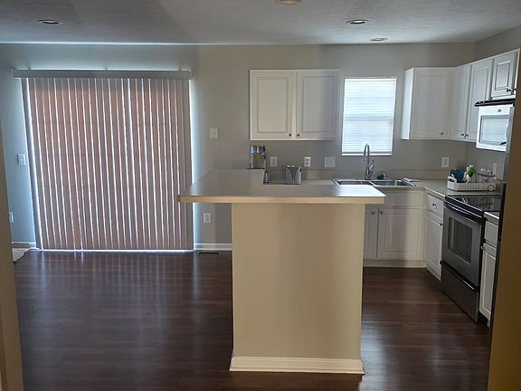 Second view of kitchen with sliding glass doors to balcony.