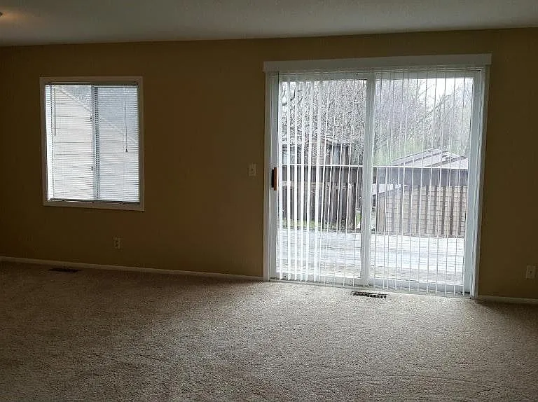 Living room with walkout to a large private deck (flooring just replaced - no longer carpeted)