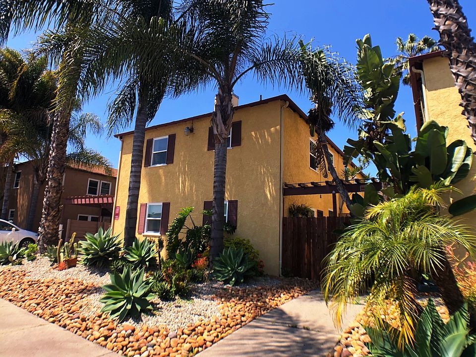 Carefully landscaped succulent garden flanked by regal palms provides captivating curb appeal.