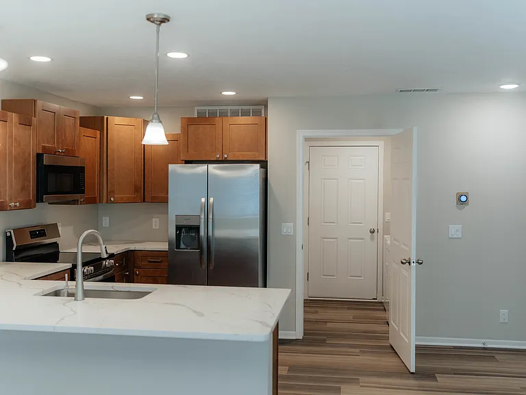 Easy to work in kitchen - U-shaped with new appliances, two lazy susans, and white quartz counters.