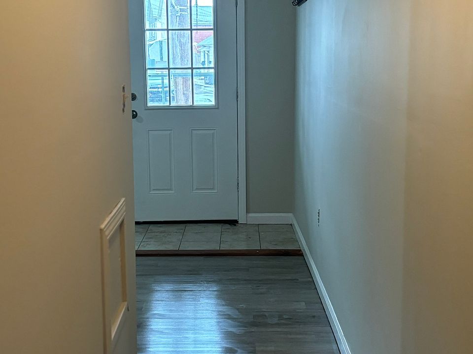 Front door to hallway leading to kitchen.