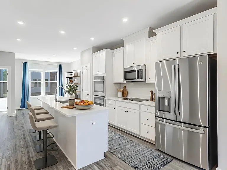 Modern open kitchen with quartz countertops, stainless steel appliances, and plenty of space for cooking and entertaining. Virtually staged.