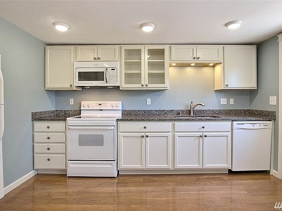Beautifully renovated kitchen with newer: High Quality Flooring; Quartz Countertops, Stainless Steel Fixtures & Large Sink, Abundant Cabinets & LED Lighting.