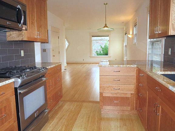 Open concept Kitchen flows to living and dining area. Plenty of storage in custom cherry cabinets.