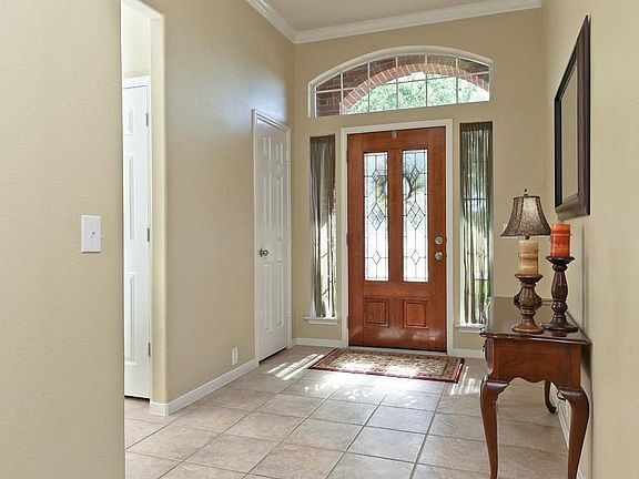 Entry has leaded glass door with decorative transom window and ceramic tile flooring