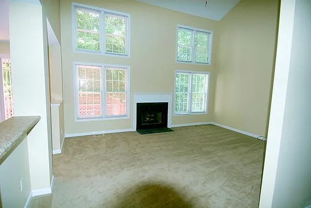 Living room with beautiful bright windows and views. Gas log fireplace