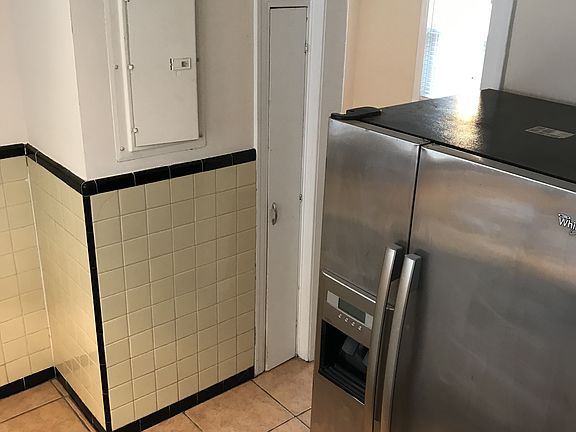 Kitchen with stainless steel fridge and handy broom closet.