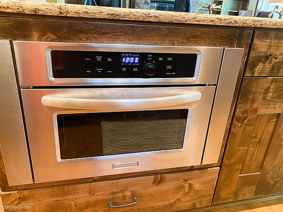 Microwave, drawers, and cupboard are on the kitchen side of the island.