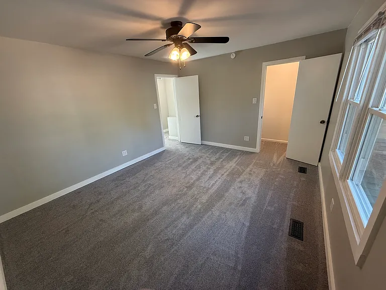 Front bedroom view to hallway door and walk-in closet
Agreeable gray throughout with gloss white trim
