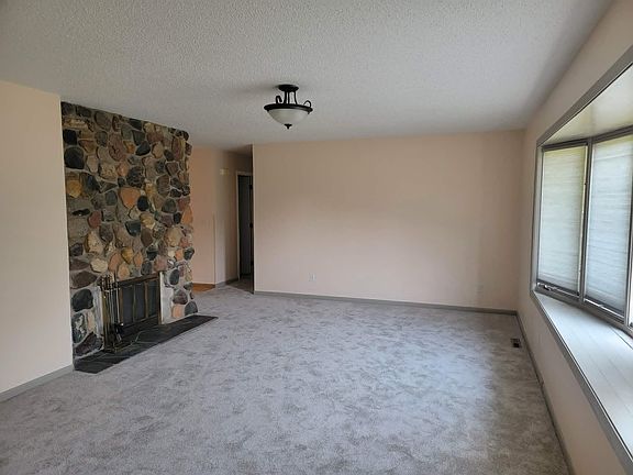 Living room. Granite stone fireplace for ambiance only (no fires allowed). New paint, carpet, cellular shades,