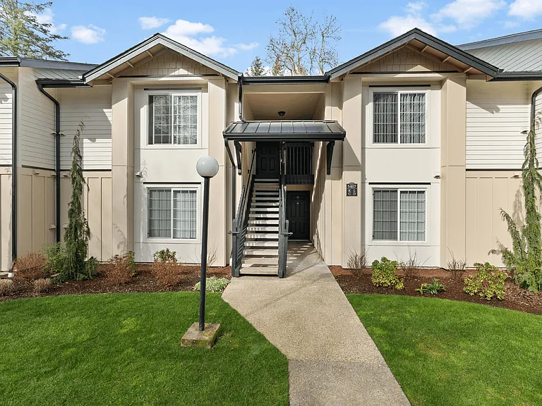 Renovated apartment homes at Boardwalk at University Place featuring landscaped grounds and convenient central building entrances.