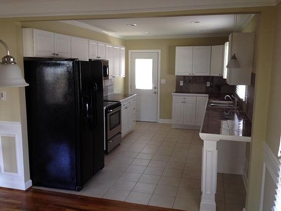 Kitchen with rear door to deck and stairs to yard and driveway