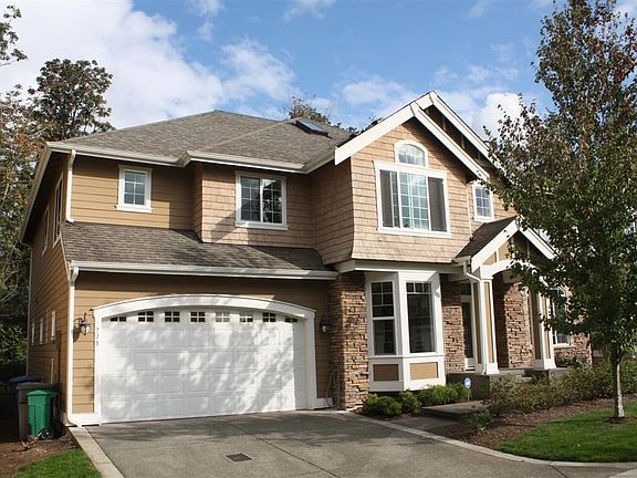 Tandem three car garage, stone and shingle accents, HardiPlank siding.