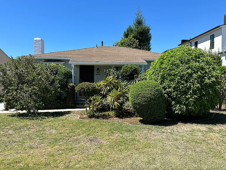 Front of property with shrubbery and trees for privacy.