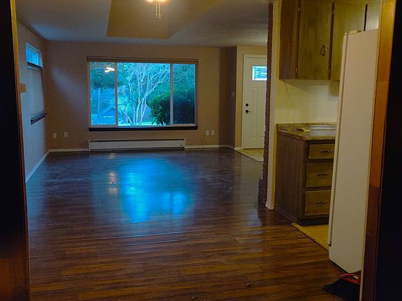 From the Den in the rear of the house looking towards the front door into the largest living area - the original Living Room/Dining Room combo as was common in the 1960''s.