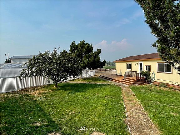 The home features three bedrooms and two full bathrooms, including a master suite with walk-in closet and is fully air conditioned (new heat pump 2015.) Mature fruit and pine trees flank the entry gate.