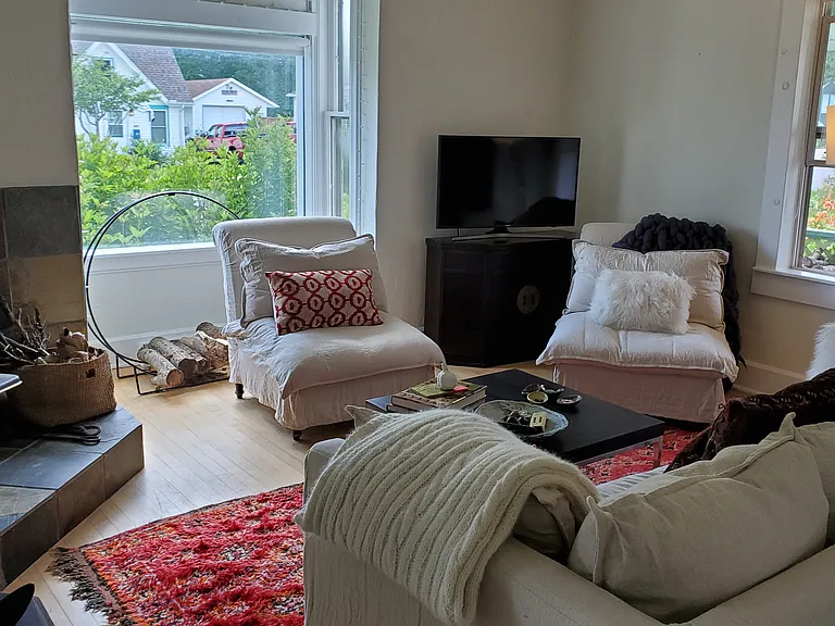 The living room has windows on three sides and faces south