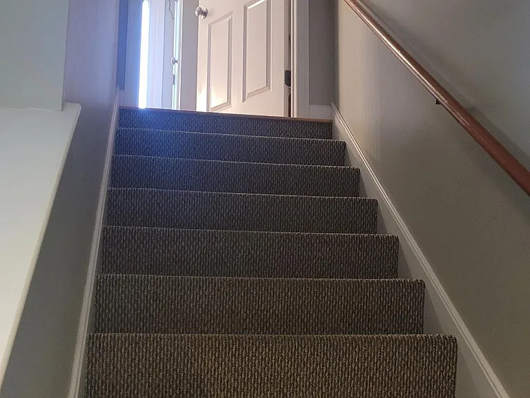 Stairs to lower level leading to separate laundry room and garage