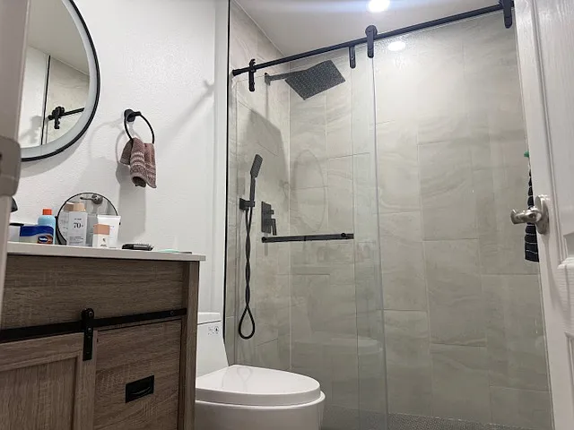 Modern upgraded bathroom with sleek vanity and walk-in glass shower.