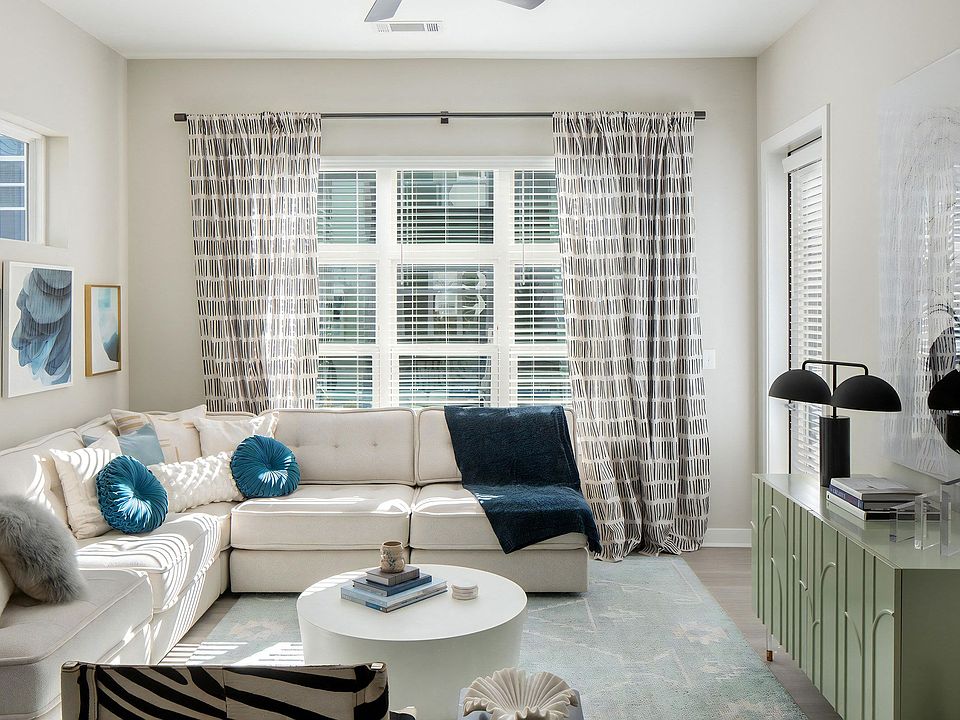 Living Room Featuring Sectional Sofa, Ceiling Fan, and Multiple Window Views