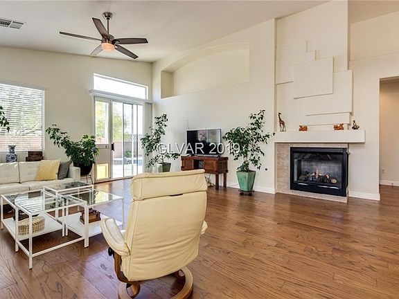 Great room has wood floors and an inviting fireplace...Vaulted ceilings make the home feel larger and airy...
