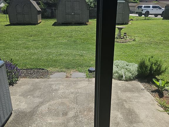 View of patio from inside living room sliding glass door looking out.
