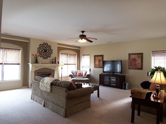 Family Room w/ dramatic fireplace, decorative mantel & custom blinds.