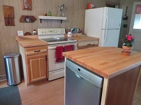 Kitchen with glass top range and island with dish washer.