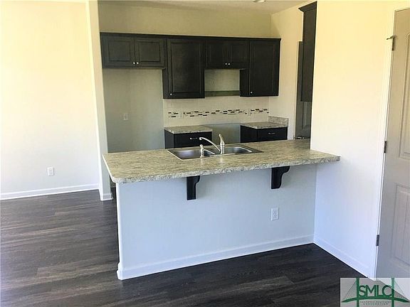 Kitchen With Dark Cabinets and Tile Backsplash